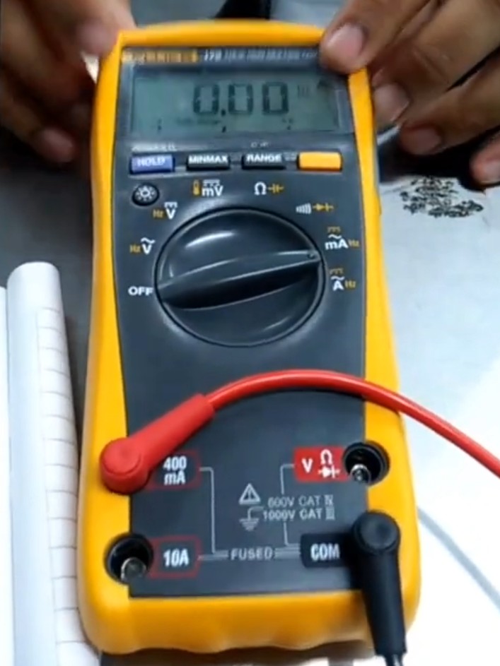 Medición de señal 4-20mA con multímetro digital en regleta de bornes de un armario eléctrico. Se aprecian etiquetas de identificación en cables y bornes tipo test.